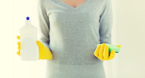 Local cleaner tidying a modern Greenwich apartment kitchen